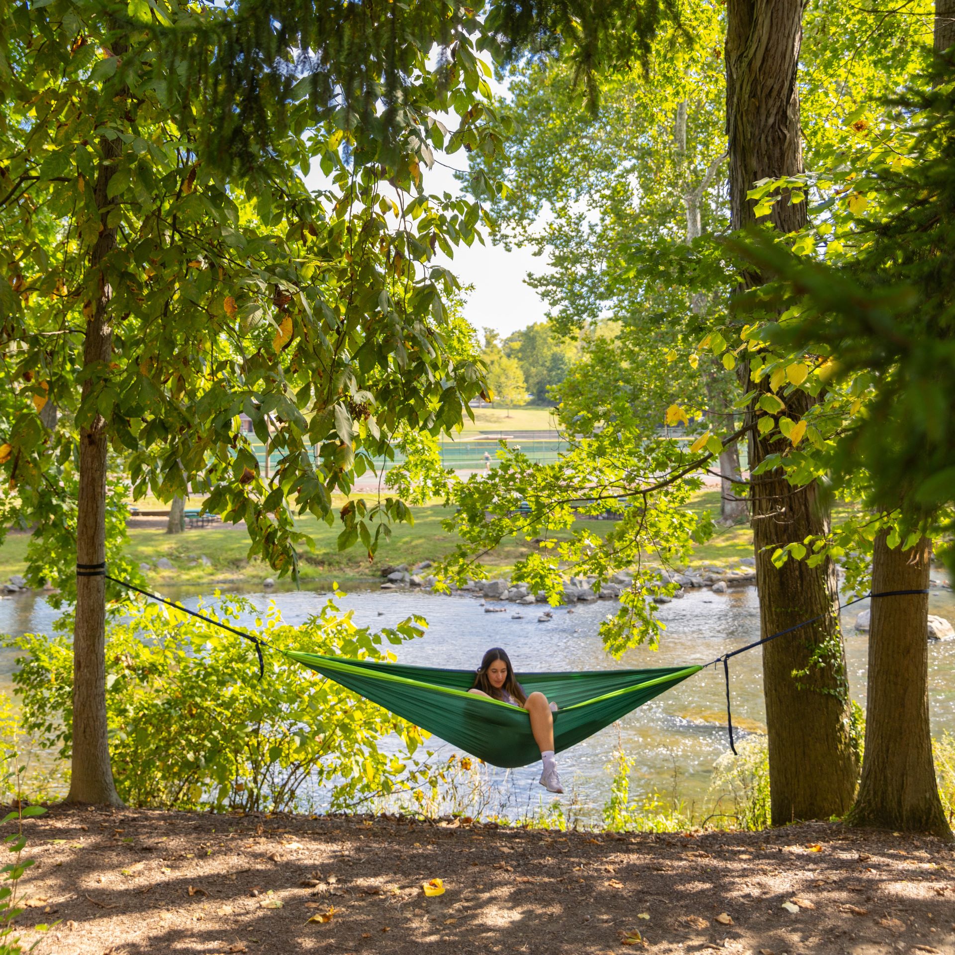 messiah students lounging in hammock alongside Yellow Breches creek