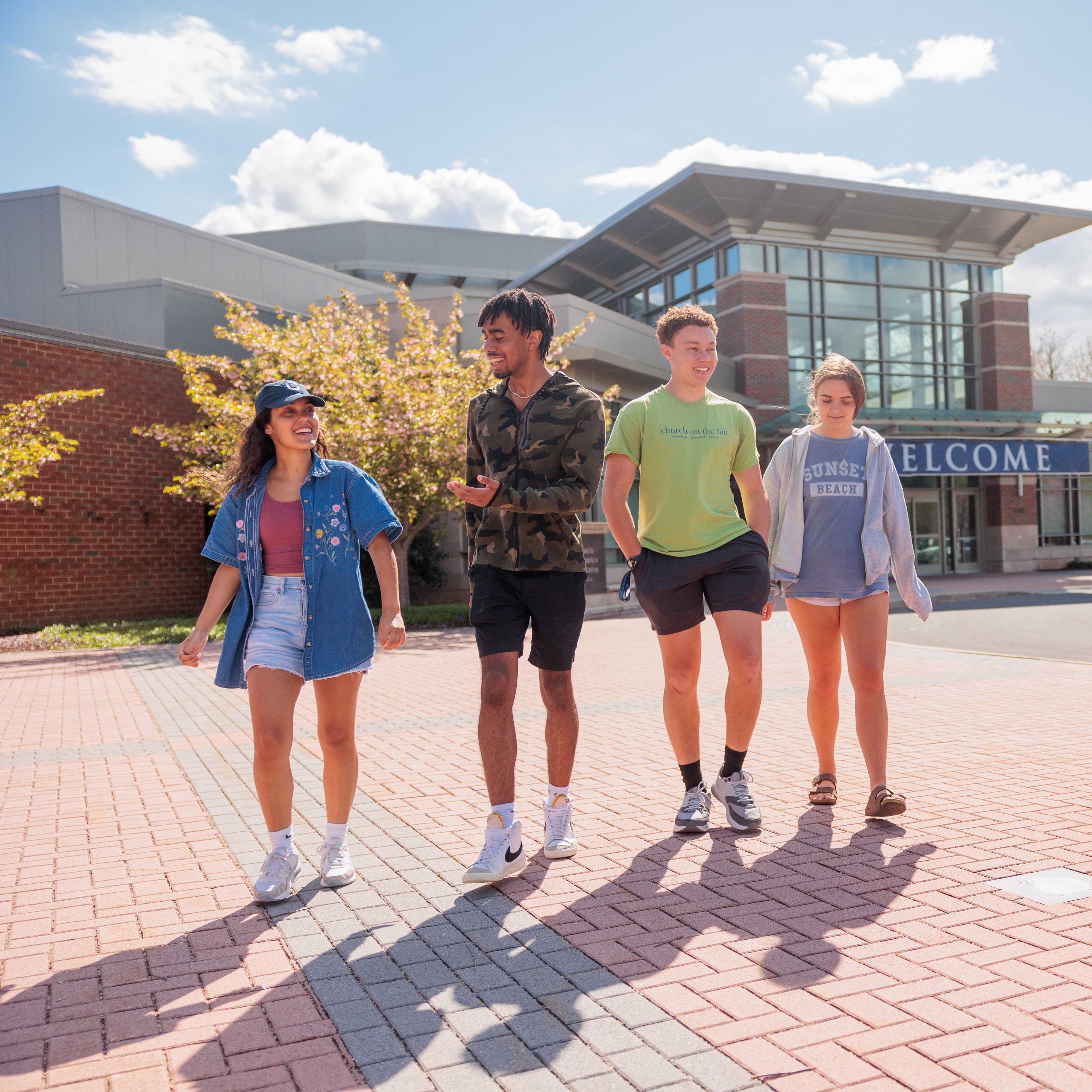 group of 4 students walking together and talking outside High Center